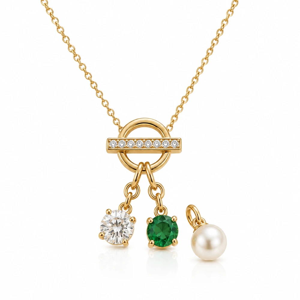 The Charm Toggle Necklace — Toggle pavé 12 mm · Charm berlian 0,25 ct + emerald 0,30 ct + mutiara 7 mm · Rantai 45 cm · Emas 18K